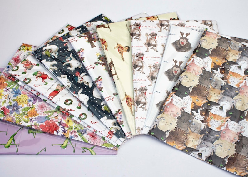 Puede incluir: Una variedad de dise&ntilde;os de papel de regalo coloridos con diferentes temas navide&ntilde;os. Los dise&ntilde;os incluyen un mu&ntilde;eco de nieve, duendes, flores, gatos y una criatura de la pel&iacute;cula 'El Se&ntilde;or de los Anillos'.