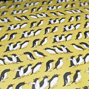 Puede incluir: Un fondo amarillo con un patr&oacute;n repetitivo de ping&uuml;inos negros y blancos. Los ping&uuml;inos est&aacute;n mirando en diferentes direcciones y algunos est&aacute;n en pleno vuelo.