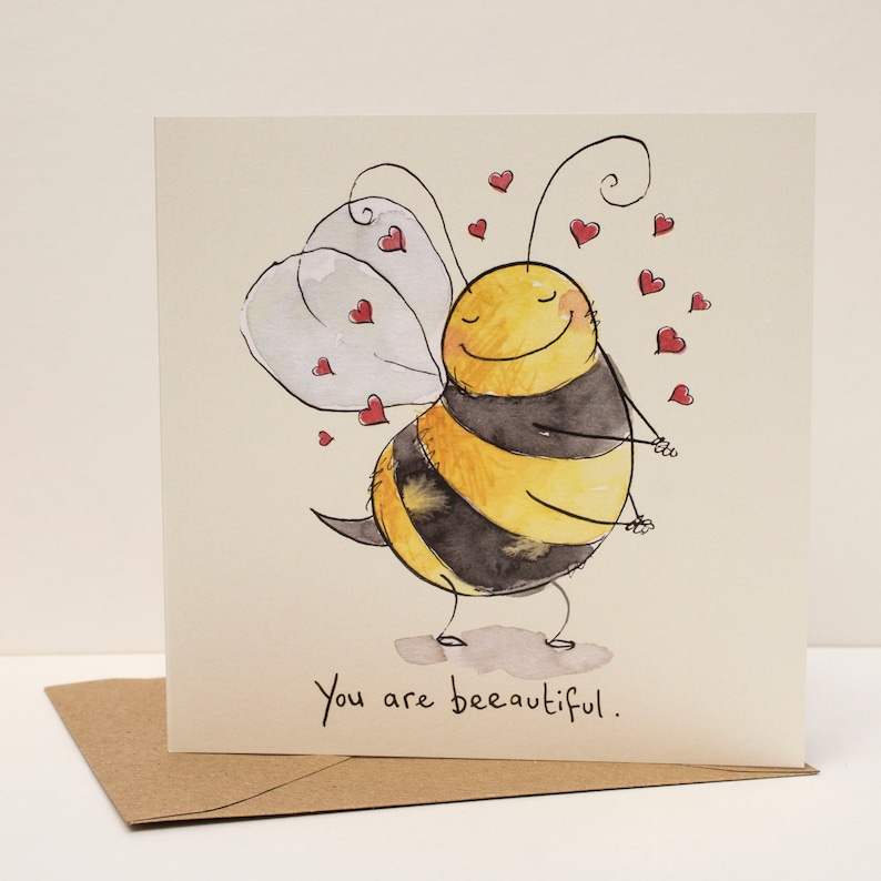 Op de afbeelding: Een aquarel-illustratie van een cartoon-bij met een gelukkige uitdrukking, omringd door rode harten. De bij is geel en zwart met witte vleugels. De tekst "You are bee-autiful." staat onder de bij.