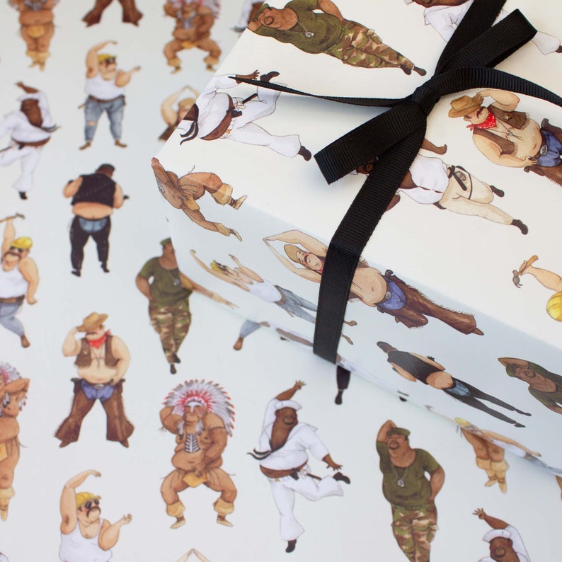 May include: White wrapping paper featuring a repeating pattern of illustrated figures in various outfits, including a cowboy, a martial artist, and a construction worker. The wrapped gift is tied with a black ribbon.
