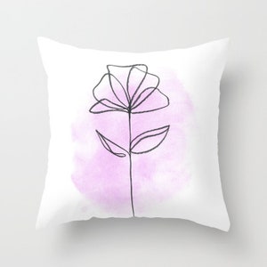 May include: A white throw pillow with a black line drawing of a flower on a pink watercolor background.