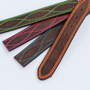 May include: Four dark brown leather straps featuring decorative stitching in vibrant neon colors. Three straps display a repeating crisscross pattern in lime green, hot pink, and bright blue, while the fourth strap has orange edge stitching.