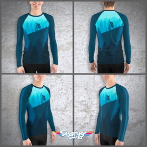 May include: A blue long-sleeve shirt with a graphic of a mountain biker riding through a forest. The shirt has a white stripe on the sleeves and a white crew neck.