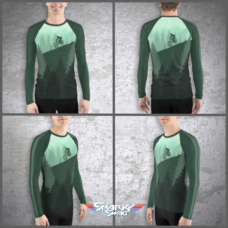 May include: A green long-sleeve shirt with a mountain biking design. The shirt has a white and green color scheme and features a silhouette of a mountain biker riding down a hill.