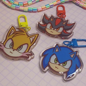 Puede incluir: Tres encantos de personajes con Sonic the Hedgehog, Tails y Shadow the Hedgehog. Cada encanto está hecho de acrílico transparente con una imagen colorida del personaje. Los encantos tienen anillos de metal para sujetarlos a un llavero o bolso.