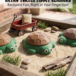 May include: Green turtle-shaped fidget clickers with brown shell tops, set in a sandbox with a miniature red wagon and a small bag labeled "SAND". The text above reads "RETRO TURTLE FIDGET CLICKERS".