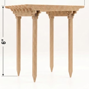 May include: A small, wooden table with a decorative top and four legs. The table is 6 inches wide and 6 inches tall. The wood has a natural, light brown color and a textured surface. The table is designed for decorative purposes.