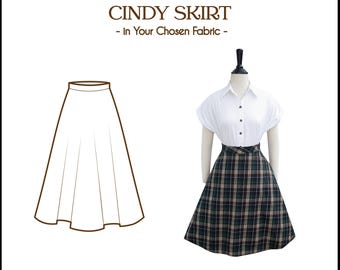 Puede incluir: Un dibujo de línea de una falda sobre un fondo blanco. La falda es de línea A y llega a la rodilla. La falda se muestra en un maniquí que lleva una camisa blanca. El texto "Tailor-Made CINDY SKIRT - In Your Chosen Fabric -" está por encima de la imagen. El texto "Brilli Ladies" está debajo de la imagen.