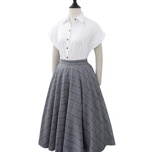 May include: A white button-down shirt with short sleeves and a gray and white plaid skirt.