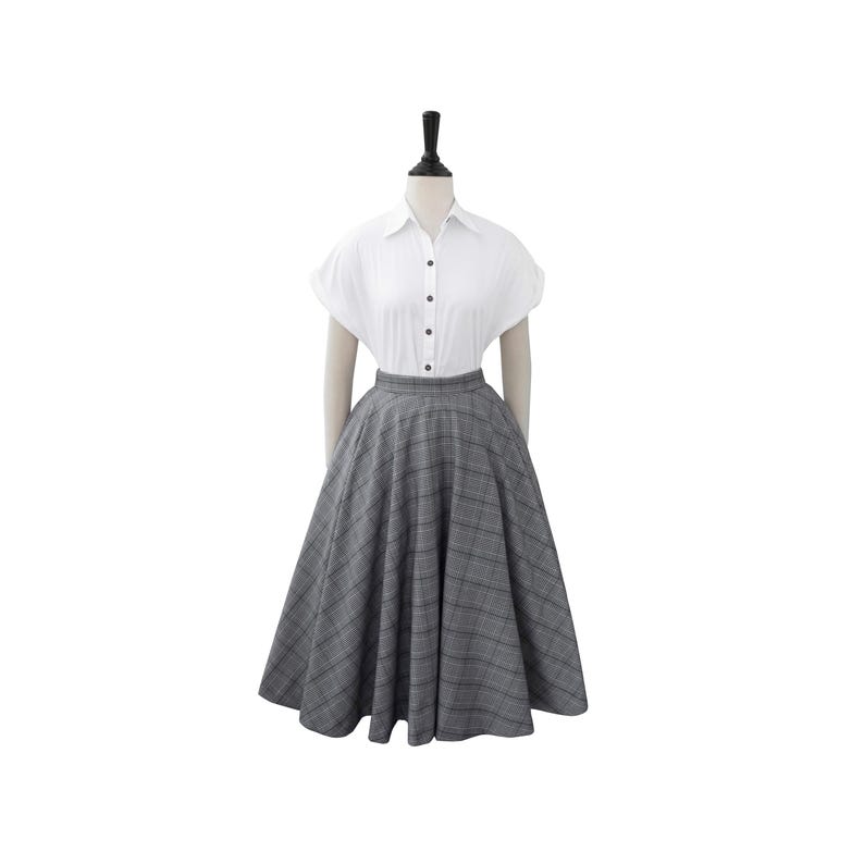 May include: A gray and black plaid skirt with a full, A-line silhouette. The skirt is knee-length and has a high waist.