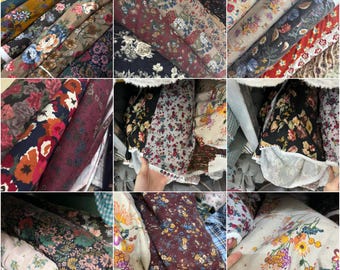 Può includere: Assortimento di rotoli di tessuto floreale in vari colori. I tessuti presentano diversi motivi floreali con colori come rosso, blu, giallo e verde. I rotoli sono ben avvolti, mostrando la varietà di disegni disponibili.