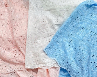 May include: Three pieces of fabric with eyelet embroidery. The fabric is pink, white, and light blue.