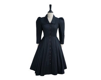 May include: A black button-up dress with a collared neckline and puffed sleeves. The dress has a fitted bodice and a full skirt.