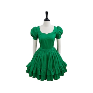 Puede incluir: Un vestido verde con escote de corazón y mangas cortas abullonadas. El vestido tiene una falda completa con tres capas de volantes.