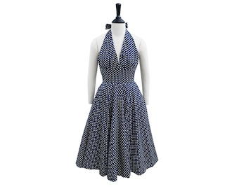 May include: A navy blue halter dress with white polka dots. The dress has a fitted bodice and a full skirt.