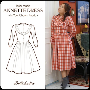 Può includere: Un disegno a linea di un vestito con un colletto a volant e maniche lunghe. Una donna indossa un vestito a quadri rosso e bianco con un colletto a volant e maniche lunghe. Il testo "Tailor-Made ANNETTE DRESS - In Your Chosen Fabric -" è nella parte superiore dell'immagine. Il testo "Brilli-Ladies" è nella parte inferiore dell'immagine.