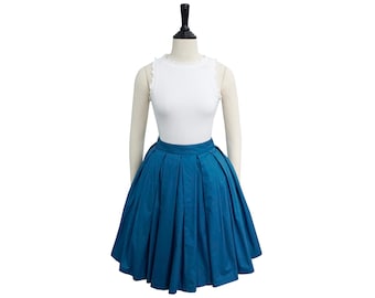 May include: A white sleeveless top with a lace trim neckline and a teal blue pleated skirt.