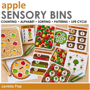 May include: An educational apple sensory bin kit featuring white plastic trays filled with oatmeal and brown crinkle paper, colorful pom-poms, green plastic tweezers, and printed activity cards labeled Apple Pie, Apple Orchard, Apple Harvest, Apple Sorting, and Apple Tree Life Cycle.