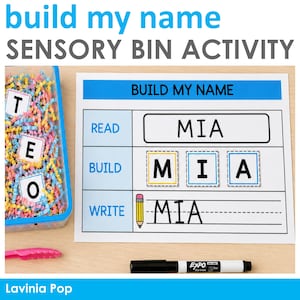 May include: A sensory bin activity set featuring a clear plastic container filled with colourful shredded paper and letter tiles, alongside a white worksheet with the text BUILD MY NAME, READ, BUILD, WRITE, and MIA, plus a pink plastic tong and marker.