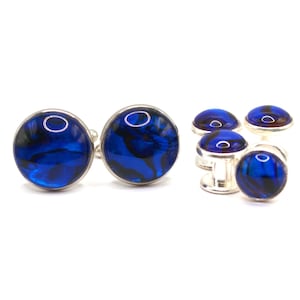 May include: Set of four blue and silver cufflinks. The cufflinks have a round, blue, iridescent design.