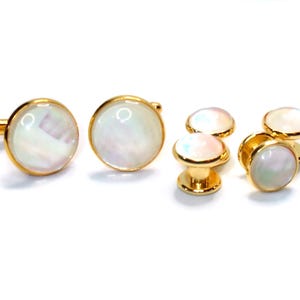 May include: Set of six gold-toned cufflinks and studs with white mother-of-pearl inlays. The cufflinks have a hinged back and the studs have a post and back.