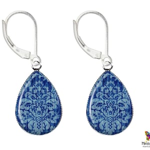 May include: A pair of silver dangle earrings with blue and white damask pattern teardrop-shaped charms.