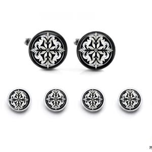 May include: A set of six cufflinks featuring a black and white geometric design. The cufflinks are round and have a silver-colored metal backing.