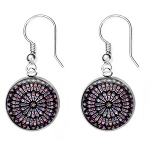 May include: A pair of silver dangle earrings with a round, colorful stained glass design. The stained glass features a circular pattern with shades of pink, purple, blue, and green.