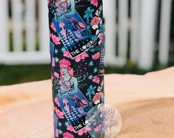 May include: A black and white tumbler with a floral pattern and images of a woman with a crown and the words "Miss Latina" and "The Lovers".