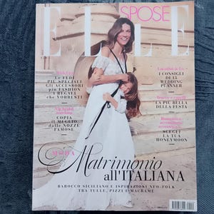 Puede incluir: Una portada de revista con una mujer y una ni&ntilde;a con vestidos blancos. El t&iacute;tulo de la revista es "ELLE SPOSE" con texto italiano debajo. La portada tiene un tema de boda, con texto sobre planificaci&oacute;n de bodas y moda.