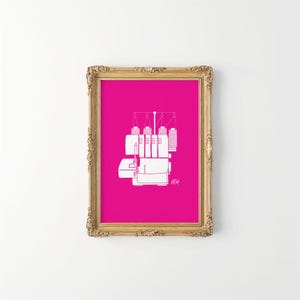 May include: A framed print featuring a white line drawing of a serger sewing machine on a vibrant pink background. The artwork is set within an ornate gold-colored frame, creating a striking contrast. The serger illustration includes details of thread spools and machine components.