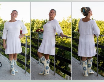 Knitted dress of white color. Knitted dress for women.  Length knee-deep. Openwork on the bottom of the sleeves and hem.