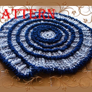 May include: A blue and white crocheted rug with a circular pattern. The rug is made of recycled t-shirts and has a textured, fluffy surface.
