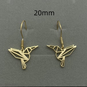 May include: A pair of gold-toned hummingbird earrings with a geometric design. The earrings are 20mm in length.