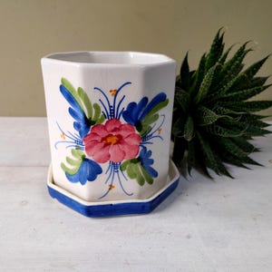 Preciosa maceta hecha con un tarro de cerámica exclusivo de Hudson's International, con decoración floral pintada a mano. ¡Un regalo encantador!