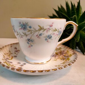 May include: A set of three ceramic mugs with a speckled, matte finish in cream, light grey, and dark grey. Each mug has a simple, minimalist design and a rounded handle.