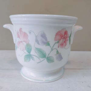 Könnte beinhalten: Weißer Keramiktopf mit zwei Griffen und einem Blumendesign mit rosa, lila und grünen Duftenden Erbsen.