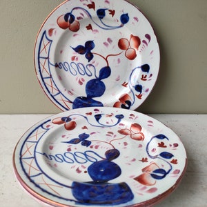 Könnte beinhalten: Drei weiße Keramikteller mit einem blauen und roten Blumendesign. Die Teller haben einen goldenen Rand und sind übereinander gestapelt.