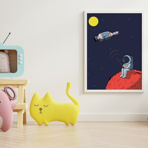 Puede incluir: Ilustraci&oacute;n enmarcada de un astronauta en un planeta rojo, con un sat&eacute;lite en el espacio. La habitaci&oacute;n presenta una estanter&iacute;a en forma de televisor azul claro con un oso, un rat&oacute;n rosa y un coj&iacute;n con forma de gato amarillo. Tambi&eacute;n hay un coche de juguete de madera y flores.
