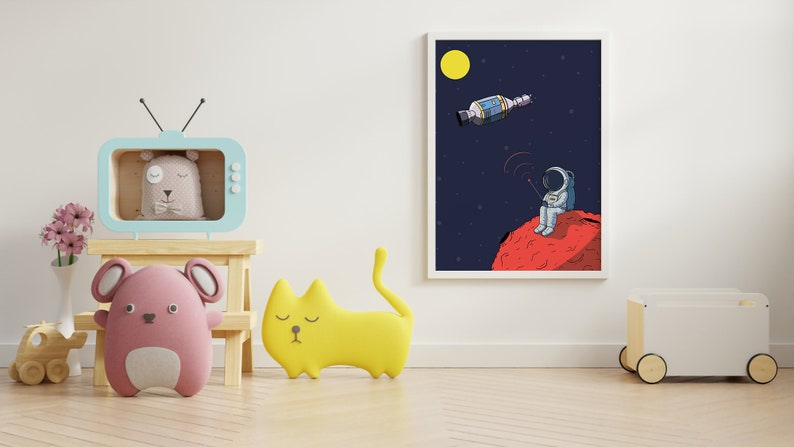 Puede incluir: Ilustraci&oacute;n enmarcada de un astronauta en un planeta rojo, con un sat&eacute;lite en el espacio. La habitaci&oacute;n presenta una estanter&iacute;a en forma de televisor azul claro con un oso, un rat&oacute;n rosa y un coj&iacute;n con forma de gato amarillo. Tambi&eacute;n hay un coche de juguete de madera y flores.