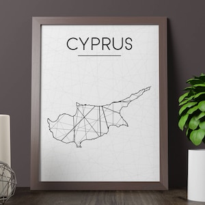 Puede incluir: Impresión enmarcada con un mapa minimalista en blanco y negro de Chipre. La palabra "CYPRUS" está encima del mapa. La impresión está en un marco marrón, con un fondo blanco y una red de líneas finas.