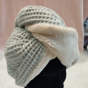 Op de afbeelding: Een lichtblauwe en crèmekleurige wafelstructuur haar turban met een zachte, pluche voering. De turban is ontworpen om vocht te absorberen en te helpen het haar snel te drogen.