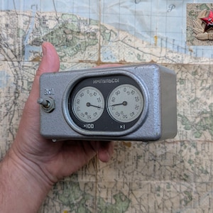 May include: A gray metal box with two round dials labeled "ИМПУЛЬСЫ" (Russian for "pulses"). The dials have numbers from 0 to 100. The box has a switch labeled "БКИ".