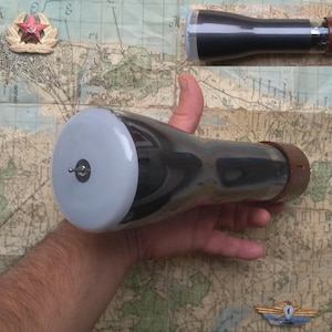 May include: A black and silver vacuum tube with a white glass end cap. The tube is approximately 25 cm long and has a brown ceramic base.