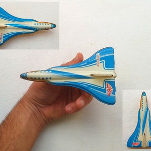 Pode incluir: Um avião de brinquedo azul e branco com detalhes vermelhos. O avião tem a palavra "Astroboy" impressa no lado.