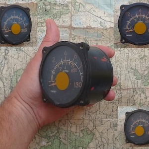 May include: Four round analog gauges with black faces, white markings, and yellow needles. The gauges have a black bezel and are labeled with the text "TROS" and "Литвы 650". The gauges read up to 1300.