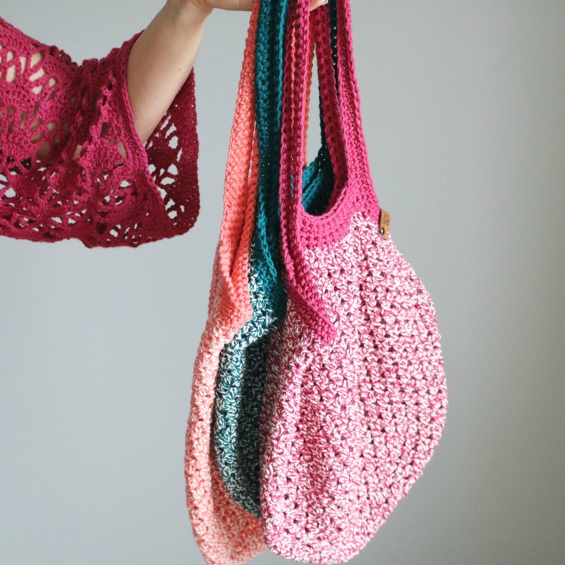May include: Three crocheted tote bags in pink, teal and coral colours. The bags are made with a textured stitch and have a simple, minimalist design.
