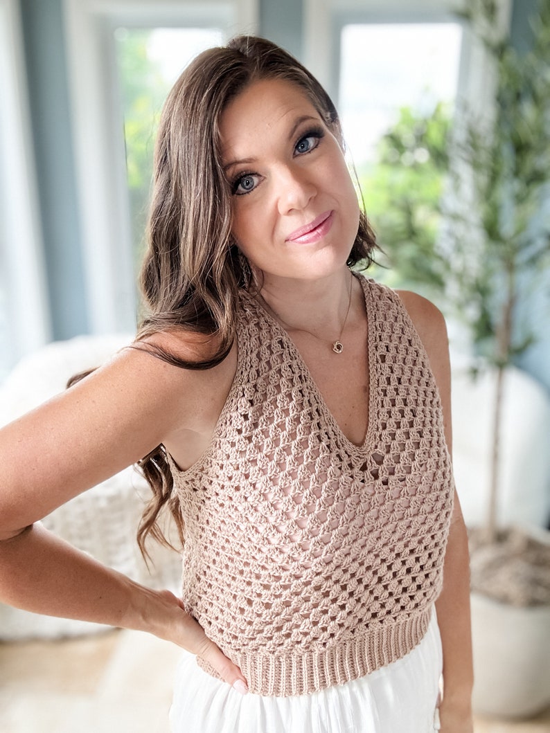 以下が含まれることがあります： Vネックの薄い茶色のクロシェの halter トップ。トップは繊細なオープンステッチパターンで作られています。