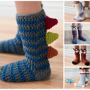 Puede incluir: Calcetines de punto de ganchillo en forma de pantuflas con diferentes diseños de animales. Los calcetines son grises, azules, blancos, marrones y morados con detalles coloridos. Los diseños incluyen un dinosaurio, un búho, un zorro y un unicornio.