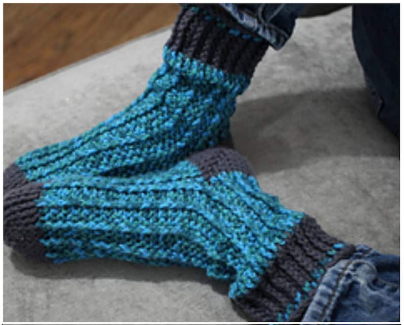 May include: A pair of blue and gray knitted socks with a textured pattern. The socks are made with a soft yarn and are perfect for keeping your feet warm in the winter.
